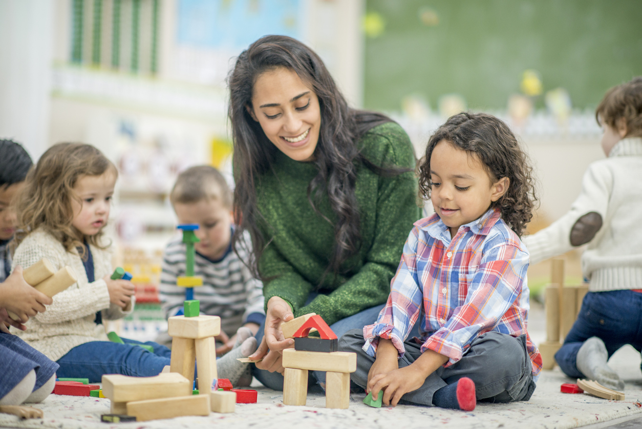 Childcare employee working with children